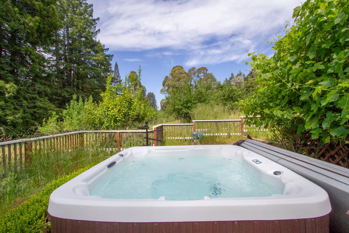 Outdoor hot tub overlooking orchard trees